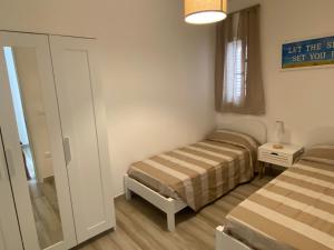 Una habitación con dos camas y un cartel en la pared. en Casa vacanze Li Marini, en Lido Marini