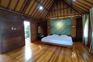 ein Schlafzimmer mit einem Bett und einem großen Fenster in der Unterkunft Argo limo Cottage Syariah Magelang in Tanayung
