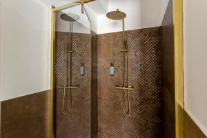bagno con doccia e piastrelle marroni di Romi Suite a Roma
