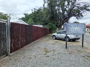 a car parked next to a fence with a sign at Klein Parys in Parys +2 photos