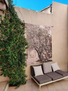 Villedieuにあるmaison sans soucisの木のある壁の横に置かれたソファ