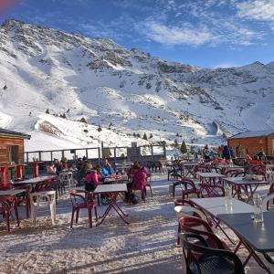 a group of people sitting at tables in front of a mountain at Studio Gaelle in Les Adrets +11 photos
