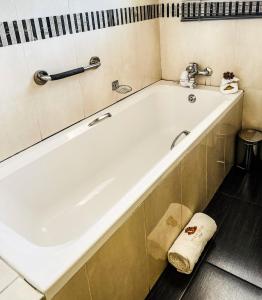 a bath tub in a bathroom with a towel on the floor at Siyaya Sbosh BnB in Reitz +34 photos