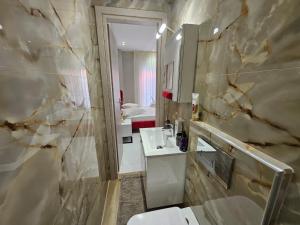 Un baño con inodoro, lavabo y espejo. en Agora luxury Studio 4, en Loutraki