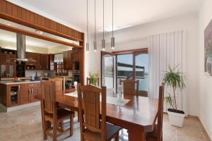 a kitchen and dining room with a wooden table and chairs at Casa Los Llanos Teseguite Lanzarote in Teguise