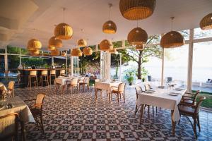 un ristorante con tavoli e sedie bianchi e finestre di Sadef Akkonak a Amasra