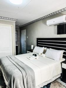 a bedroom with a large white bed in a room at Siyaya Sbosh BnB in Reitz