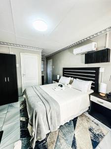 a bedroom with a large white bed in a room at Siyaya Sbosh BnB in Reitz