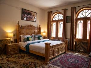 a bedroom with a large bed and two windows at Duroyo hotel in Gilgit