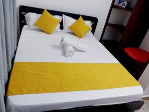 ウクンダにあるSerene Stay Dianiのベッド(黄色と白のシーツ、黄色の枕付)