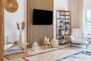 a living room with a tv and a couch and a chair at Paraiso Pueblo Pools Gym Views in Benahavís