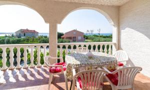 a table and chairs on a porch with a view of the ocean at Apartment Nin 531 in Nin