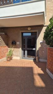 an entrance to a building with a glass door at Espo's house in Torvaianica