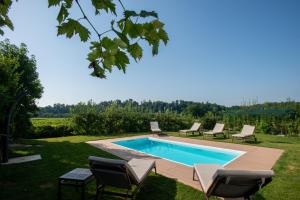 a swimming pool in a yard with chairs around it at Relais La Dolce Vite in San Vendemiano