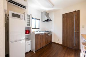 Una pequeña cocina con fregadero y refrigerador. en M Park, en Fukuoka