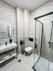 a bathroom with a toilet and a sink and a shower at Hotel Vidović in Banja Luka +96 photos