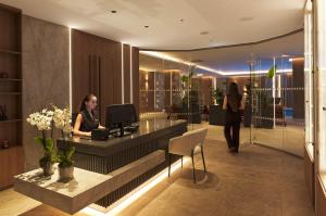 a woman sitting at a desk in a lobby at St George Beach Hotel & Spa Resort in Paphos City +132 photos