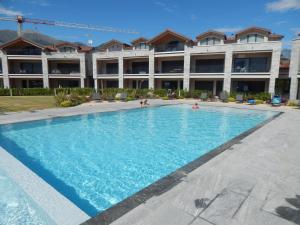 a swimming pool in front of a large building at Lago Dorato Roxy Apartament in Colico