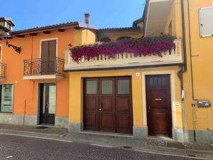 a building with two doors and a balcony with flowers at Casa da Charlie in Busca