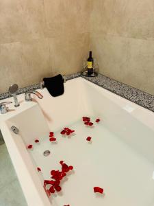 a white bath tub filled with red rose petals at Hotel Vidović in Banja Luka