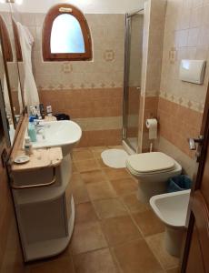 a bathroom with a sink and a toilet and a shower at Villa Erika 25 mt dalla Spiaggia in Villasimius +1 photo