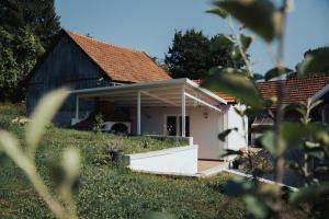 a small white house with a pitched roof at Holiday House Smilja in Ogulin