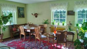 a dining room with a table and chairs and windows at Prawdzicówka in Zachełmie
