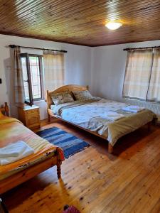 a bedroom with two beds and a wooden ceiling at Sunny Guest House in Boykovtsi
