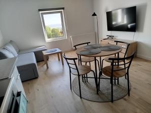 a living room with a table and chairs and a couch at Apartament Eden in Srebrna Góra +7 photos
