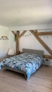a bedroom with a bed in a room with wooden floors at La perle des Lacs in Dompierre-sur-Mont