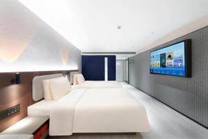 Una habitación de hotel con dos camas y un televisor de pantalla plana. en Atour Light Hotel Nanjing Chengxin Avenue Subway Station, en Jiangning