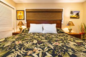 a bedroom with a bed and two lamps and two tables at Kihei Beach Resort 608 in Kihei +37 photos