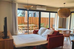 een woonkamer met een bank en een tafel bij Villa IrisJasmin jacuzzi vue mer in Lacanau