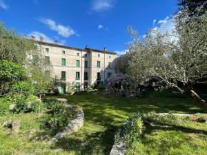 a garden in front of a large building at La maison odette in Aulas