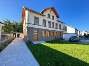 a large white house with a driveway and grass at E&K living - design Apartments - SKY-TV - Audi - IN village - free parking in Ingolstadt