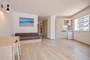 a living room with a couch and a kitchen at Sunside Ibiza Studios - Only Adults- Formerly known as Central Park in San Antonio