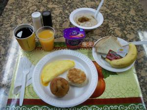a table with two plates of breakfast foods and orange juice at Days Inn by Wyndham Winona in Winona