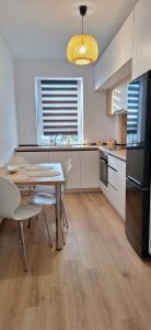 a kitchen with a table and chairs and a refrigerator at Milan Luxury Apartaments VI-Maurer Residence in Târgu-Mureş +2 photos