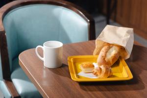 a plate of pastries and a cup of coffee on a table at KOKO HOTEL Shimbashi Onarimon in Tokyo