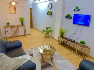 a living room with a couch and a tv at Residence Ethan Nji - Green Heaven in Yaoundé