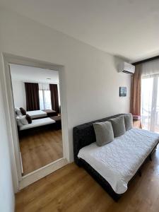 a living room with a couch and a mirror at Apartments Plaza in Ulcinj