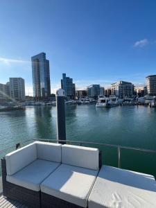 a white couch sitting on a dock next to the water at YACHT "X" - 44 FOOT MODERN YACHT ON 5 STAR OCEAN VILLAGE MARINA - minutes away from city centre and cruise terminals, Free parking ,SPA package available! in Southampton