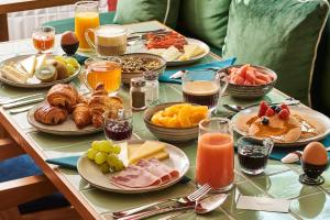a table topped with plates of breakfast foods and drinks at Mercure Paris Butte Montmartre Basilique in Paris +13 photos