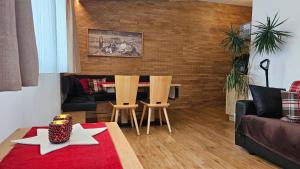 サン・ヴァレンティーノ・アッラ・ムータにあるenjoy Monika apartmentsのテーブルと椅子2脚のあるリビングルーム