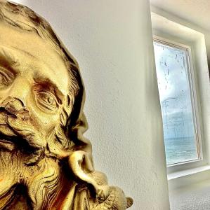 a statue of a mans face next to a window at Casal Santa Virginia in Sintra