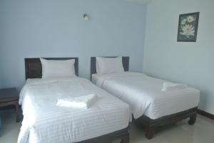 dos camas sentadas una al lado de la otra en una habitación en Baan Duangkamol en Phitsanulok