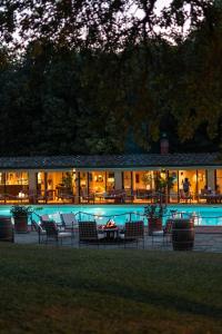 a building with a pool with chairs and a table at Borgo San Luigi in Monteriggioni