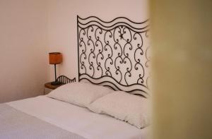 a bedroom with a white bed with a decorative headboard at Blu di Prussia in Laureana Cilento +8 photos