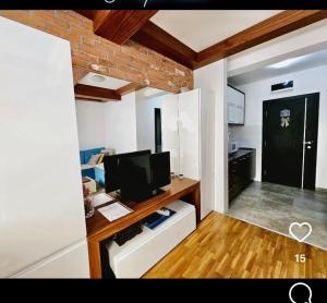 a living room with a television and a room with a door at Konak 20 Apartman 24 in Zlatibor