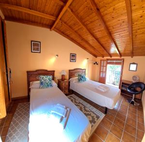 a bedroom with two beds and a wooden ceiling at Charming Villa in Carratraca, Malaga - 4 Bedrooms, Sleeps up to 8 Guest BY NAMASTE ELITE in Carratraca